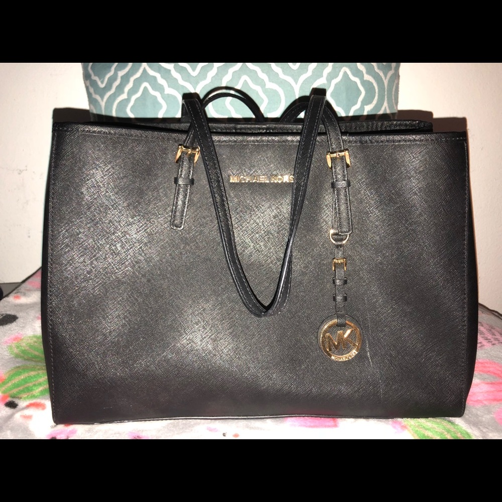 Black Michael Kors purse with duster bag.